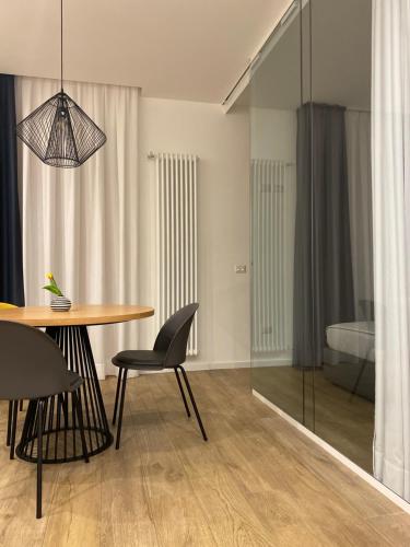 a dining room with a table and chairs and a bedroom at Nu House Rooms & Apartments in Cassano delle Murge