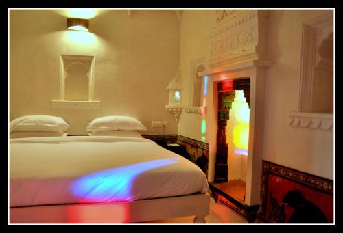 a bedroom with a bed with a colorful light on it at Madri Haveli in Udaipur
