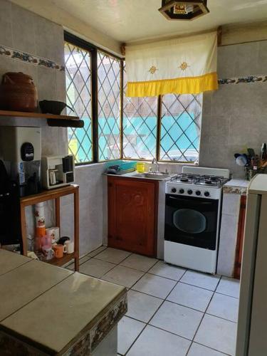 eine Küche mit einem Herd und einem Fenster in der Unterkunft Casa de campo Mi muchachito in Pátzcuaro