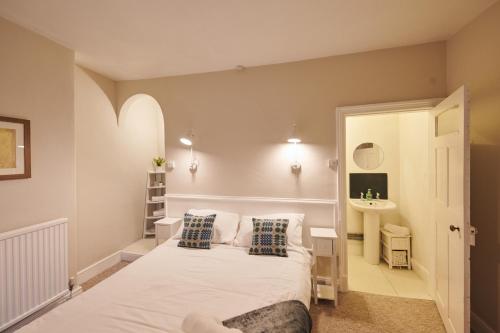 a bedroom with a white bed and a sink at The Haven in Llandeilo