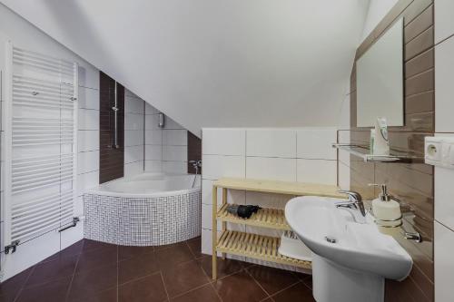 ein Badezimmer mit einem Waschbecken und einer Badewanne in der Unterkunft Horský dům OLYMPIA in Janské Lázně