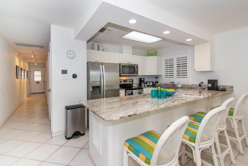 a kitchen with a large island with white counter tops at Beach Living at Discovery Point Club in West Bay