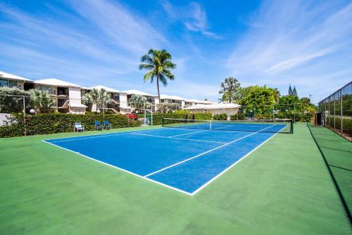 a tennis court in front of a villa at Beach Living at Discovery Point Club in West Bay