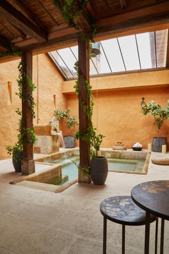 a courtyard with a pool with tables and plants at Hacienda el Potrero - Un lugar para siempre recordar in Suesca