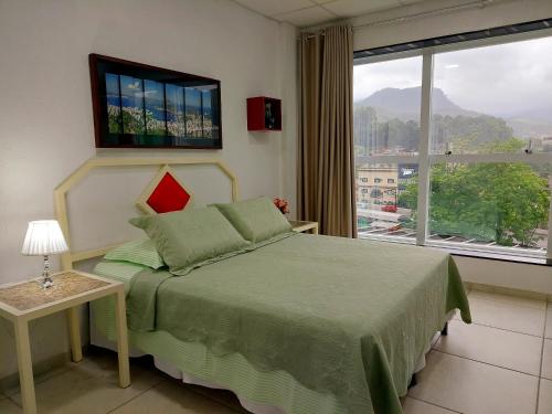 sypialnia z łóżkiem i dużym oknem w obiekcie Hotel Netto w mieście Cachoeiras de Macacu