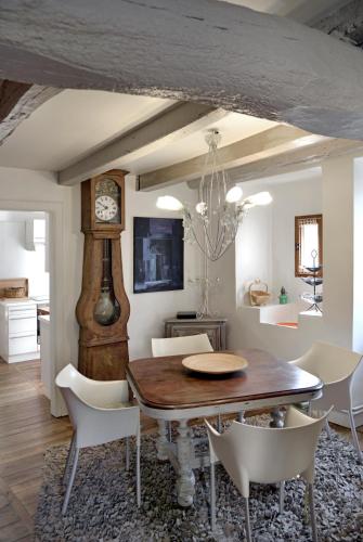 une salle à manger avec une table et une horloge dans l'établissement LES TERRASSES DE CARENNAC, à Carennac