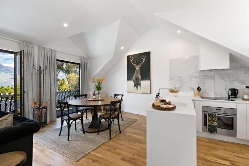 a kitchen and living room with a table and chairs at Alpine Cottage in Queenstown