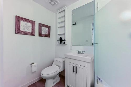 a white bathroom with a toilet and a sink at Stylish 1-bedroom loft in Gas Town in Vancouver