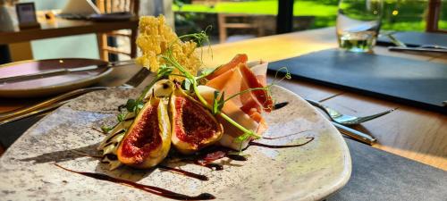 a plate of food with fruit and vegetables on a table at Biggin Hall Country House Hotel in Hartington