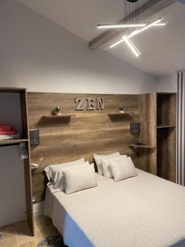 1 dormitorio con 1 cama y pared de madera en Loft atlantique Rochefort en Rochefort