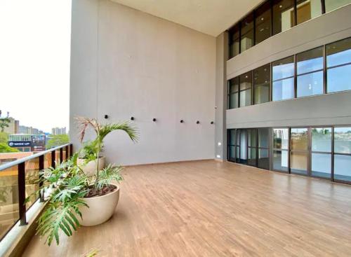 a large white building with a balcony with plants at Loft Executivo-Afonso Pena in Campo Grande