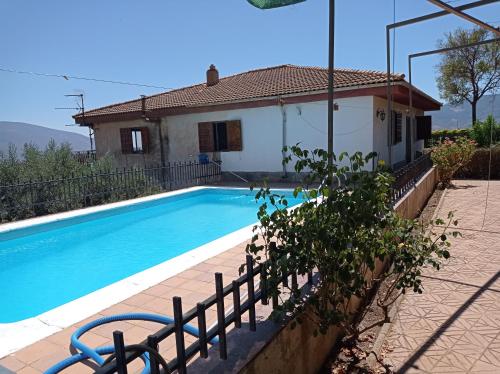 a villa with a swimming pool in front of a house at Chalet Venta del Aire in Lanjarón