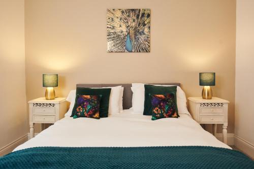 a bedroom with a white bed with two night stands at Towy Snug in Llandeilo