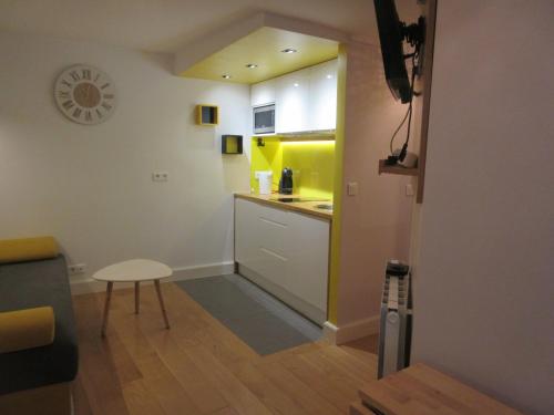 uma pequena cozinha com uma mesa e um balcão amarelo em Cosy Studio of 17 square meters at Place Monge 75005 em Paris