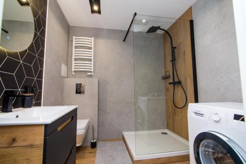 a bathroom with a sink and a washing machine at Apartament KOPERNIK w centrum in Iława
