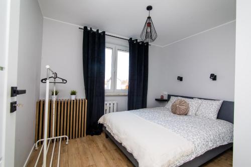 a bedroom with a bed and a radiator at Apartament KOPERNIK w centrum in Iława