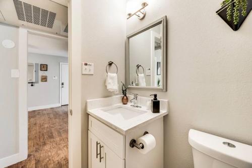 a white bathroom with a sink and a mirror at Love for Dallas: Close to Deep Ellum & AAC! in Dallas