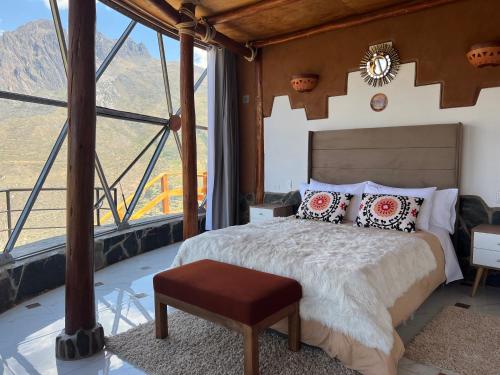 a bedroom with a bed and a large window at Stardome Spiritual Experience in Ollantaytambo