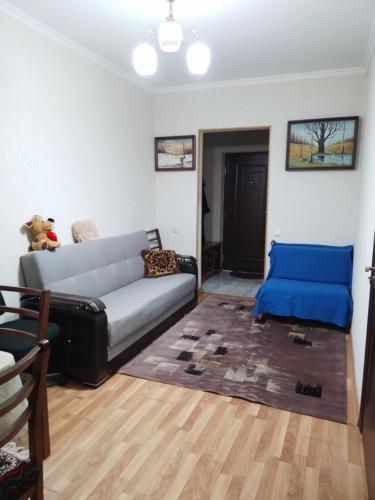 a living room with a couch and a blue chair at Apartment in Tbilisi City