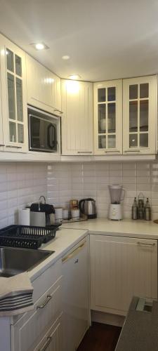 une cuisine avec des armoires blanches et un micro-ondes dans l'établissement STUDIO CANNES STELLAMARE, à Cannes