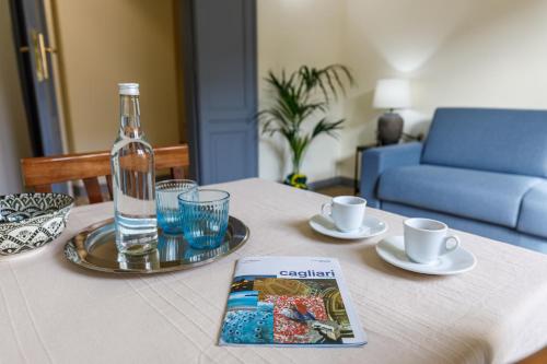 - une table avec une bouteille d'eau et un livre dans l'établissement Onlyrooms IV - Sea View & Free Parking, à Cagliari