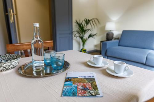 una mesa con una botella de agua y un libro sobre ella en Onlyrooms IV - Sea View & Free Parking, en Cagliari