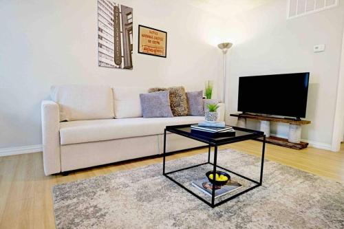 a living room with a couch and a tv at Global Cup Dwell By Design & Arboretum Tickets Included in Dallas