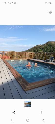 Una foto de una piscina con dos personas. en Chez Gisèle et Philippe en Terre-de-Haut