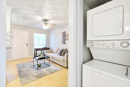 a white living room with a couch and a kitchen at Global Cup Dwell By Design & Arboretum Tickets Included in Dallas