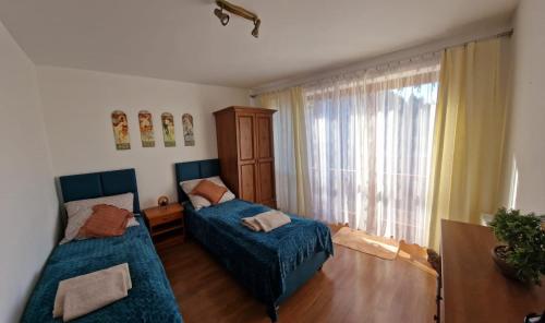 un soggiorno con 2 letti e una finestra di Skalna View Apartament z widokiem dwie sypialnie i salon balkon parking a Karpacz