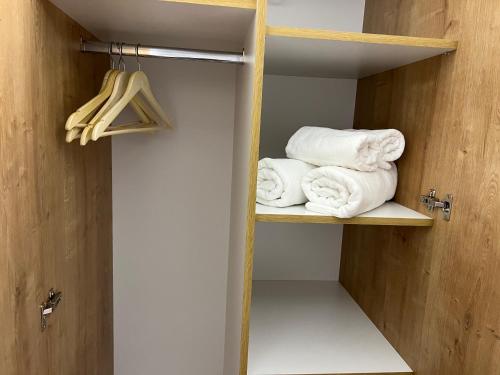 a closet with towels on a shelf next to a door at Casa cu Flori Maramures 