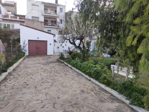 a stone walkway with a red door and a building at CAL TIO PAU in Orba