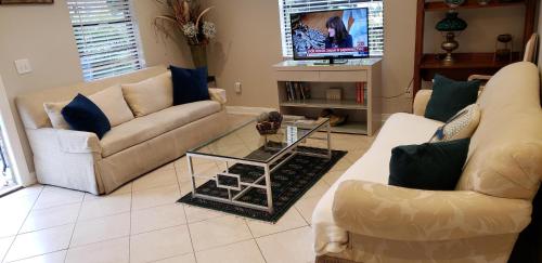 a living room with two couches and a tv at OCEAN VACATION BREEZE in Lantana
