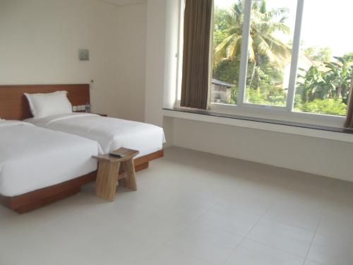 a hotel room with two beds and a window at L Bajo Hotel in Labuan Bajo