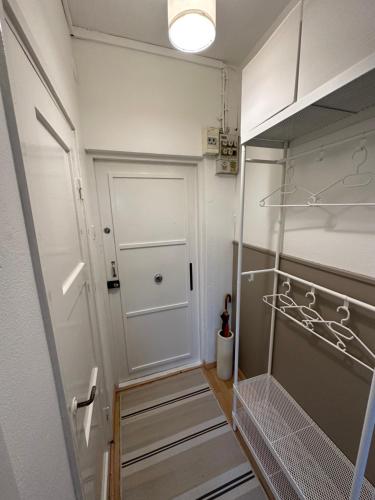 a walk in closet with a white door and shelves at Cozy apartment in Vallila - Helsinki in Helsinki