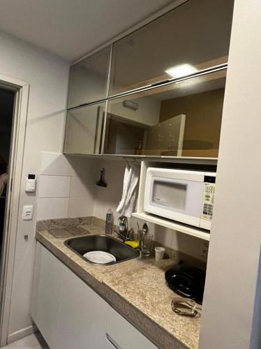 a kitchen with a sink and a microwave at Flat Setor de Hotéis Norte no Hotel Fusion in Brasília
