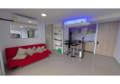 a living room with a red couch and a kitchen at INCREIBLE APARTAMENTO Puerto Azul Club House RICAURTE in Ricaurte