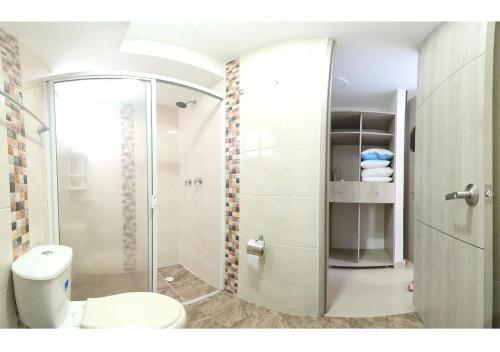 a bathroom with a toilet and a glass shower at INCREIBLE APARTAMENTO Puerto Azul Club House RICAURTE in Ricaurte