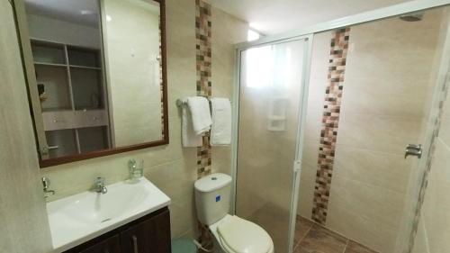 a bathroom with a toilet and a sink and a shower at INCREIBLE APARTAMENTO Puerto Azul Club House RICAURTE in Ricaurte