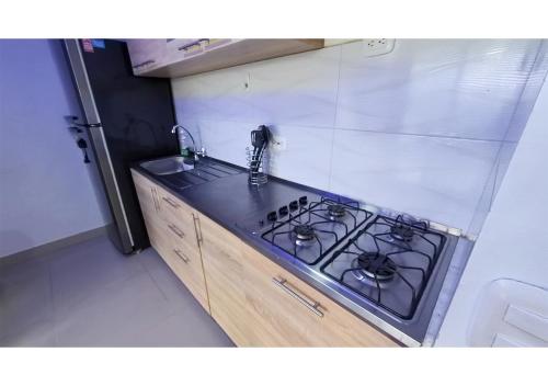a kitchen with a stove and a counter top at INCREIBLE APARTAMENTO Puerto Azul Club House RICAURTE in Ricaurte