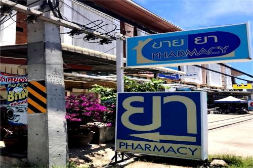 a pharmacy sign on a pole in front of a building at Hua Hin First-Hin Nam in Hua Hin