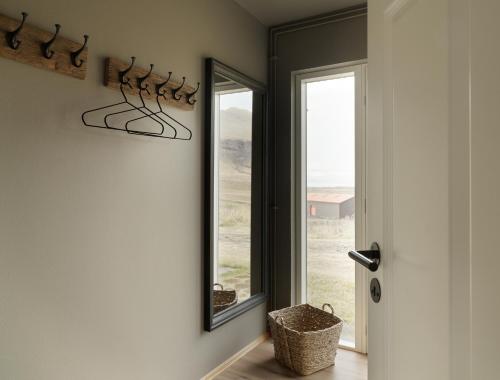 a hallway with a mirror and a door with a basket at Klöpp Lodge - Snæfellsnes Peninsula in Stykkishólmur