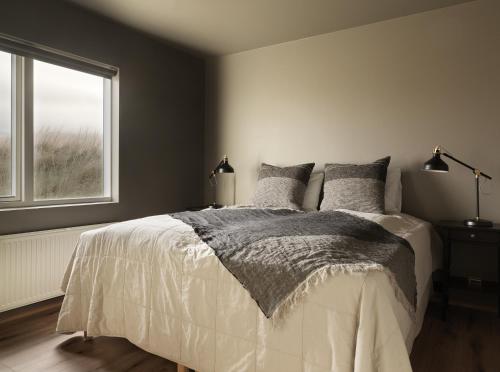 a bedroom with a bed and a window at Klöpp Lodge - Snæfellsnes Peninsula in Stykkishólmur