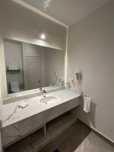 a bathroom with a sink and a large mirror at Villa 19 Con Playa 2 Recamaras dentro de Hotel en Ixtapa in Ixtapa