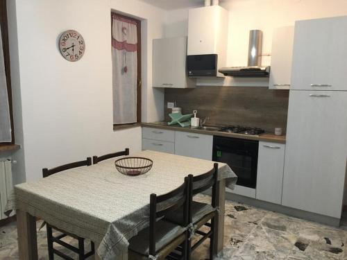 a kitchen with a table and chairs and a kitchen with white cabinets at Casa Bianca in Frabosa Sottana