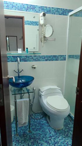 a blue and white bathroom with a toilet and a sink at Atlantis Plaza Hotel Cúcuta in Cúcuta