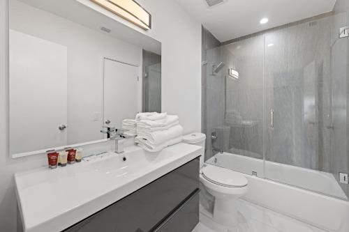 a white bathroom with a sink and a toilet and a tub at Private Spacious House #BBQ - Hallandale Beach, Florida in Hallandale Beach