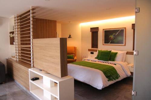 a bedroom with a large bed with green pillows at The Lu'um House in Tuxtla Gutiérrez