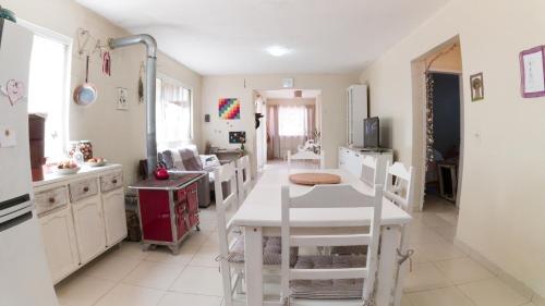 a kitchen with a white table and white chairs at Casa Familiar Estaleiro in Balneário Camboriú