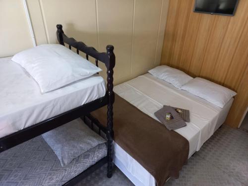 two bunk beds in a small room with a tray on top at Suíte Barros in Navegantes